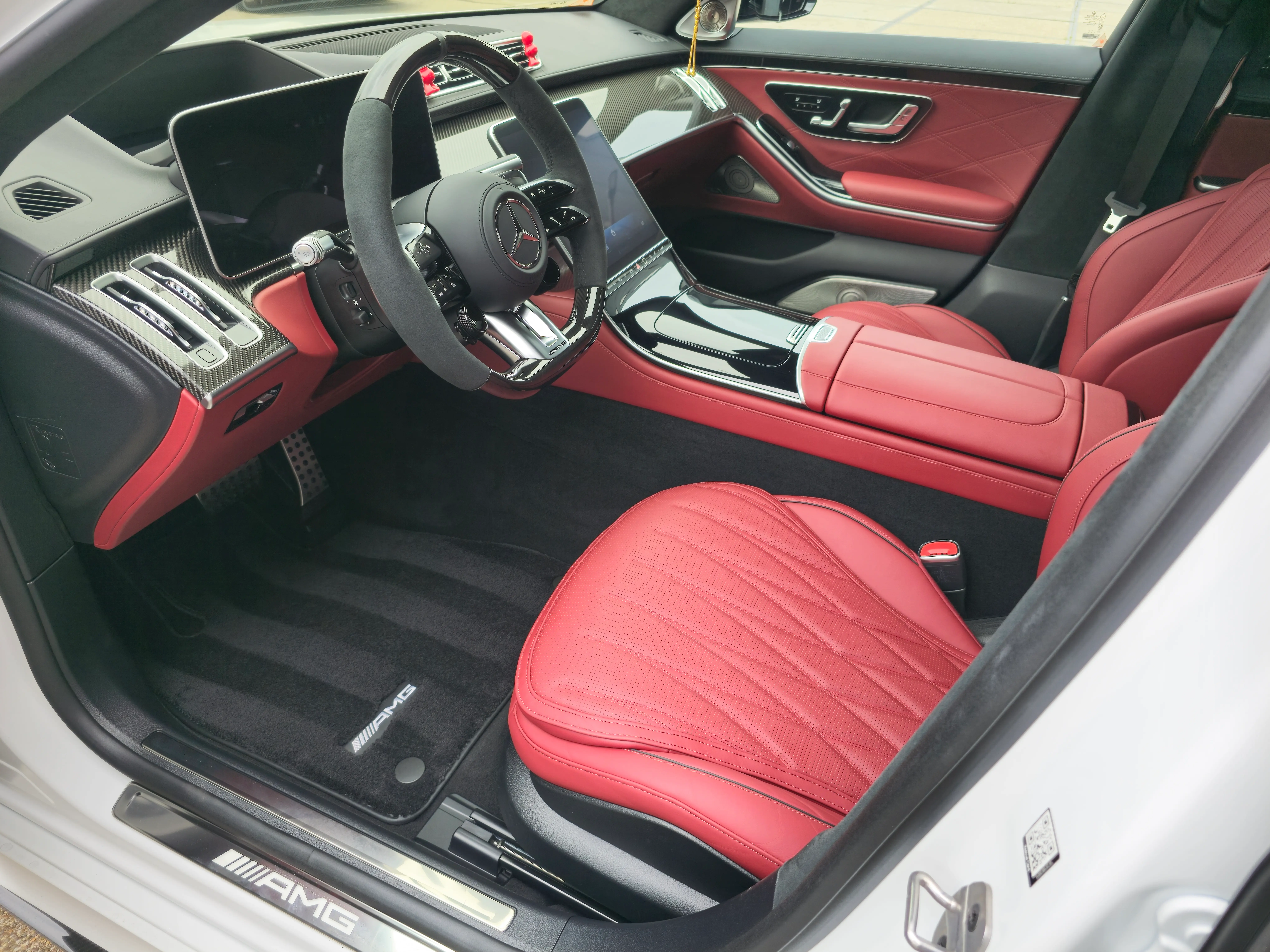 Rood interieur van een witte Mercedes-AMG S63 vanuit de bestuurderszijde